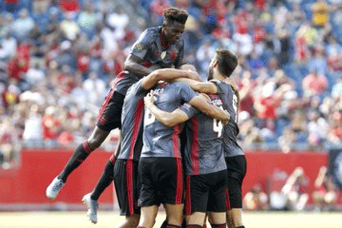 Benfica players celebrate a goal against AC Milan on Sunday