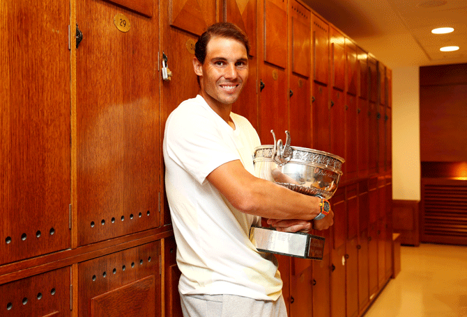 Spain's Rafael Nadal celebrates in the locker room with his 18th Grand Slam trophy and his 12th French Open title at Roland Garros in Paris, on Sunday