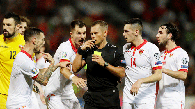 Montenegro's Igor Vujacic is shown a yellow card by referee Vladislav Bezborodov, awarding Czech Republic a penalty during their Group A match at Andruv Stadion in Olomouc, Czech Republic, on Monday
