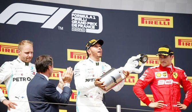 Mercedes driver Lewis Hamilton celebrates on the podium after winning the French Grand Prix, alongside second-placed Mercedes's Valtteri Bottas and third-placed Ferrari's Charles Leclerc