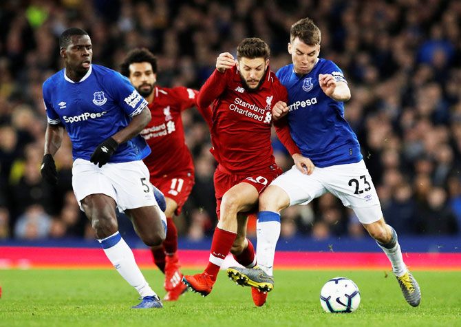 Liverpool's Adam Lallana (left) challenges Everton's Seamus Coleman and Kurt Zouma as they vie for possession