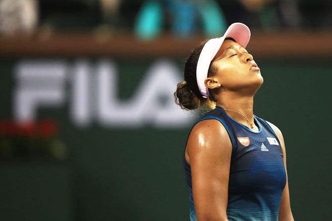 Japa's Naomi Osaka reacts during her loss to Switzerland's Belinda Bencic on Day 9  of the BNP Paribas Open at the Indian Wells Tennis Garden in Indian Wells, California, on Tuesday