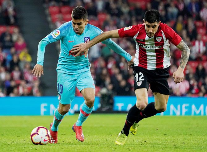 Atletico Madrid's Angel Correa and Athletic Bilbao's Yuri Berchiche vie for possession at San Mames in Bilbao on Saturday