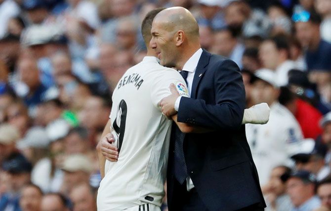 Real Madrid's Karim Benzema is embraced by coach Zinedine Zidane after being substituted off during their La Liga match against Celta Vigo on Saturday