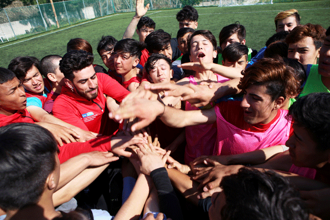 Refugee children gesture their hands during a football training in Mytilene city, on the island of Lesbos, Greece