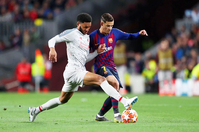 Liverpool's Joe Gomez battles for the ball with Barcelona's Philippe Coutinho