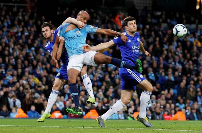 Leicester City's Ben Chilwell and Harry Maguire vie for the ball in an aerial battle with Manchester City's Vincent Kompany