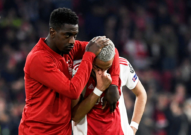 Ajax's Hakim Ziyech is consoled by a teammate after their loss to Tottenham