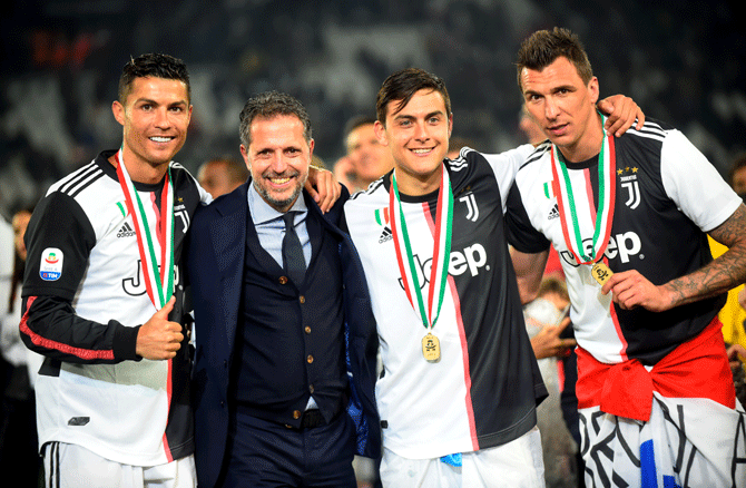 Juventus' Cristiano Ronaldo poses as he celebrates winning Serie A with general manager Fabio Paratici, teammate Paulo Dybala and Mario Mandzukic at Allianz Stadium, Turin on Sunday