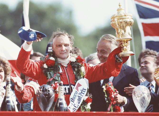 Austria's Niki Lauda and driver of the #8 Marlboro McLaren International McLaren MP4B Ford Cosworth DFV V8 lifts the RAC Trophy and celebrates winning the Marlboro British Grand Prix on 18 July 1982 at the Brands Hatch circuit in Fawkham, Great Britain