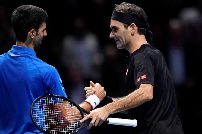 Roger Federer and Novak Djokovic meet at the net after the match.