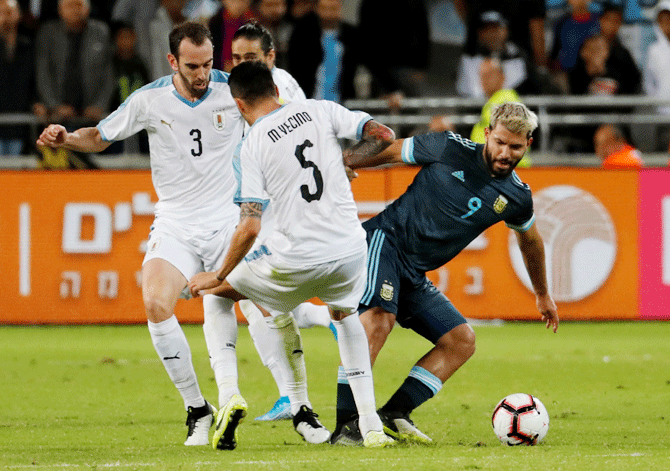 Argentina's Sergio Aguero is challenged by Uruguay's Matias Vecino and Diego Godin