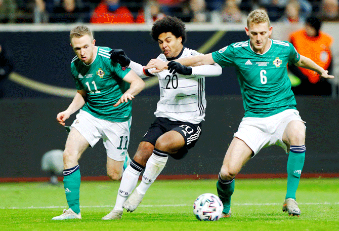 Germany's Serge Gnabry is challenged by Northern Ireland's George Saville and Shane Ferguson as they vie for possession during their Euro 2020 Qualifier Group C match at Commerzbank-Arena, Frankfurt, Germany, on Tuesday