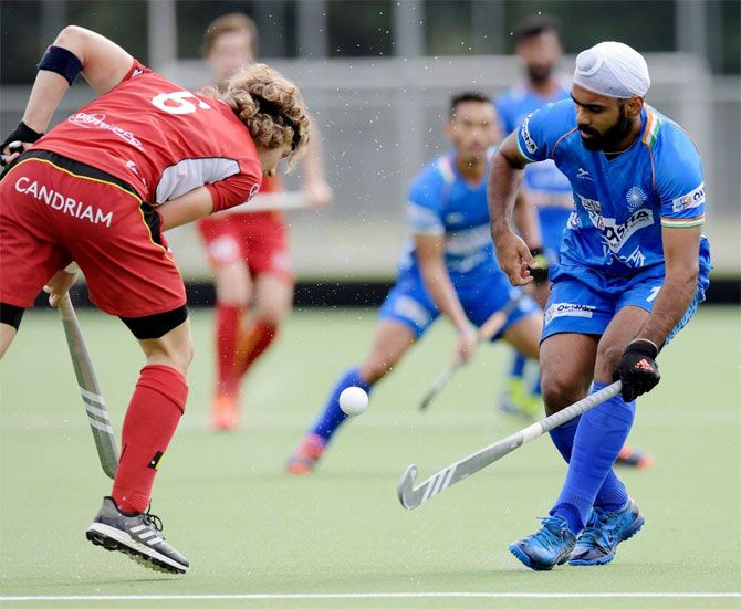 Indis's Simranjeet Singh (right) who scored the 2nd goal for India, vies with a Belgian player during their match in Antwerp, Belgium, on Tuesday