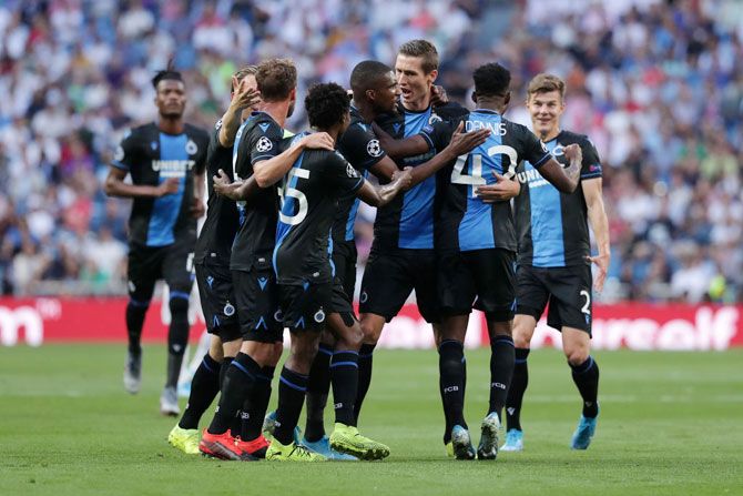Club Brugge's Emmanuel Bonaventure Dennis celebrates with teammates after scoring his team's first goal against Real Madrid during their UEFA Champions League Group A match at Santiago Bernabeu in Madrid on Tuesday