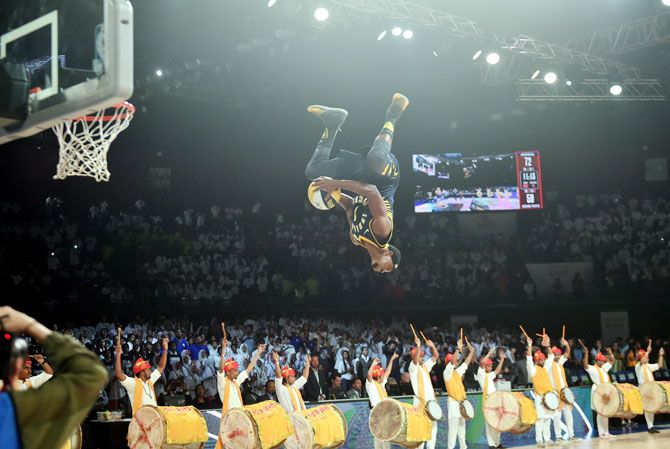 A member of the Indiana Pacers Powerpack performs a dunk off a trampoline, at the half-time show, during the during the NBA pre-season game played between Sacramento Kings and Indiana Pacers in Mumbai on Friday