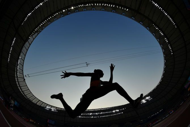 An athlete competes during the women's triple jump qualification