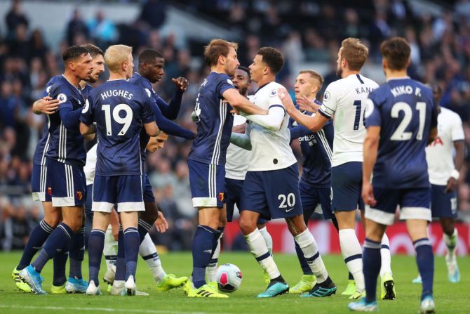 Tottenham Hotspur's Dele Alli clashes with Watford's Craig Dawson during their match at Tottenham Hotspur Stadium 
