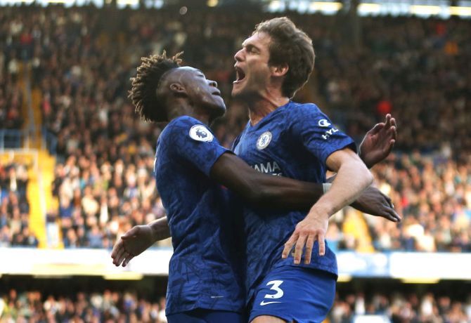 Chelsea's Marcos Alonso celebrates with teammate Tammy Abraham after scoring against Newcastle United at Stamford Bridge