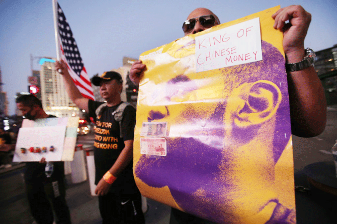 A pro-Hong Kong activist holds a poster of LeBron James with the words 'King of Chinese Money' before the Los Angeles Lakers season opening game against the LA Clippers outside Staples Center in Los Angeles, California, on Tuesday. Activists also printed at least 10,000 pro-Hong Kong t-shirts to hand out to those attending the game and encouraged them to wear the free shirts as a form of peaceful protest against China amidst Chinese censorship of NBA games