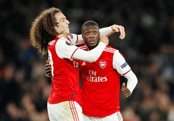 Arsenal's Nicolas Pepe celebrates with teammate Matteo Guendouzi after scoring their third goal against Vitoria S.C. in their Europa League Group F match at Emirates Stadium in London on Thursday