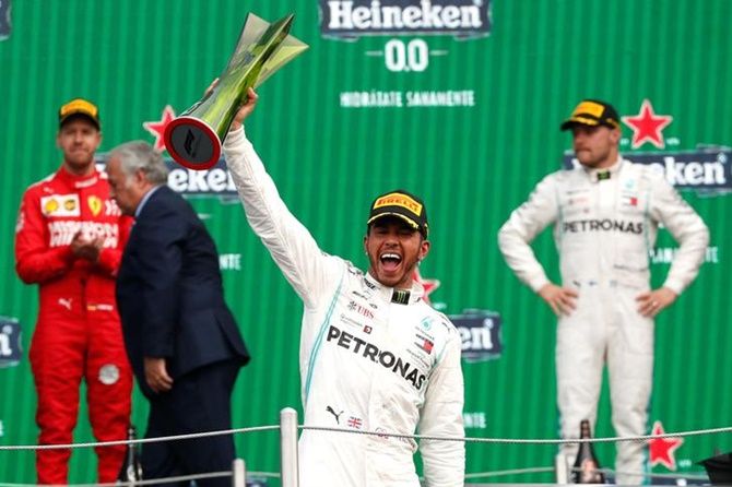 Mercedes's Lewis Hamilton celebrates with the trophy after winning the Mexican Grand Prix