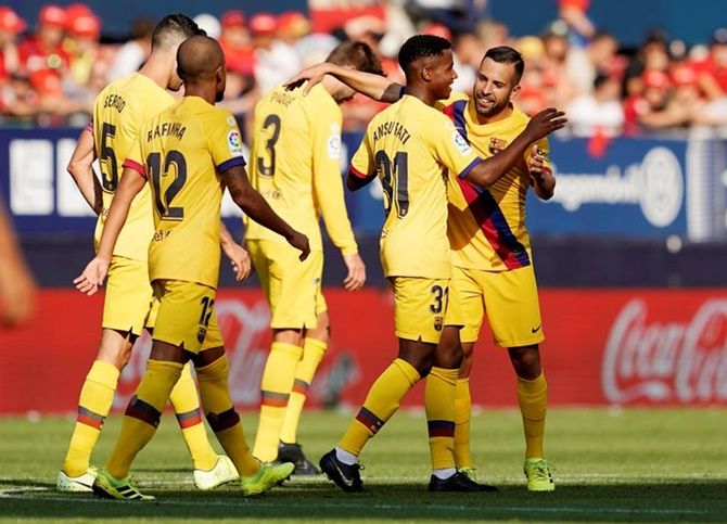Barcelona's 16-year-old Anssumane Fati is congratulated by teammates after scoring in Saturday's La Liga match against Osasuna.