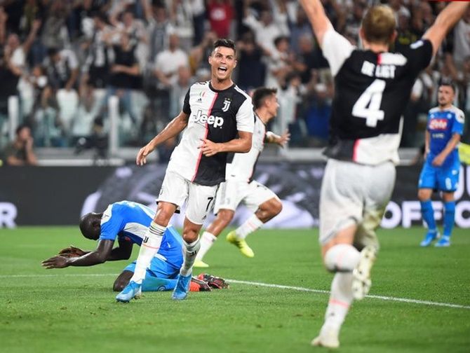 Napoli's Kalidou Koulibaly is dejected after scoring an own goal as Juventus's Cristiano Ronaldo and Matthijs de Ligt celebrate.