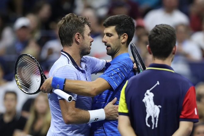 Novak Djokovic, right, embraces Stan Wawrinka after retiring due to a shoulder injury during their men's singles fourth round match on Sunday, Day 7 of the US Open.