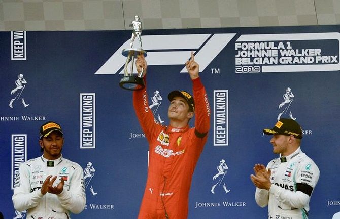 Ferrari's Charles Leclerc celebrates with the trophy on the podium after winning the Formula One Belgian Grand Prix.