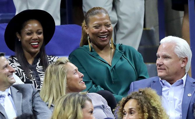 Hollywood actress Queen Latifah, right, shares a laugh with friends, while the she attends the match between Serena Williams and Wang Qiang