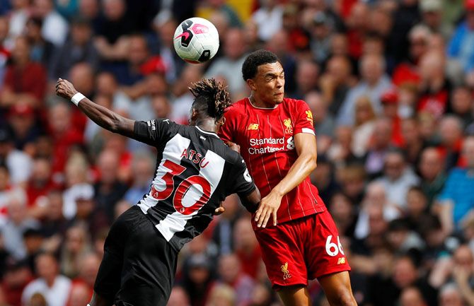 Newcastle United's Christian Atsu and with Liverpool's Trent Alexander-Arnold in an aerial battle 