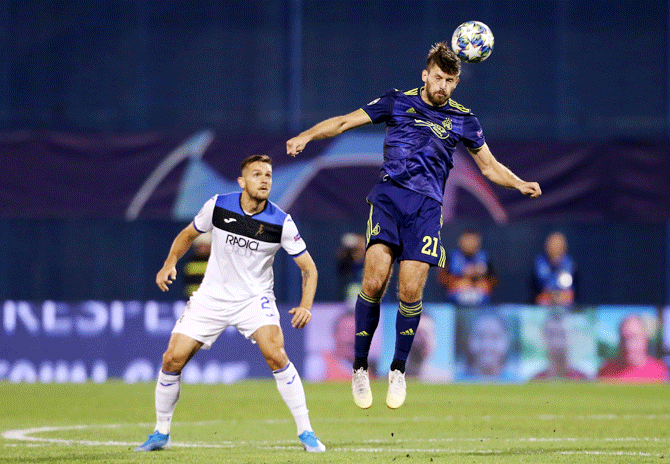 GNK Dinamo Zagreb's Bruno Petkovic wins an aerial ball as Atalanta's Rafael Toloi looks on during their Champions League Group C match at Stadion Maksimir, Zagreb