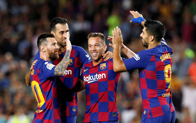 Barcelona's Arthur celebrates with teammates Lionel Messi and Luis Suarez after scoring their second goal against Villareal 