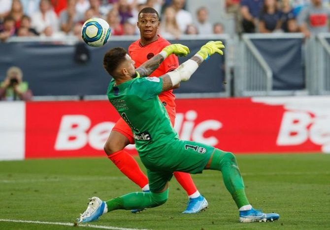 Paris St Germain's Kylian Mbappe shoots at goal as Bordeaux's Benoit Costil attempts to save