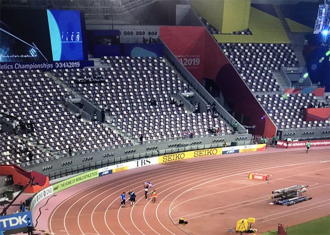 An athlete takes a lap of honour in front of a near-empty stand