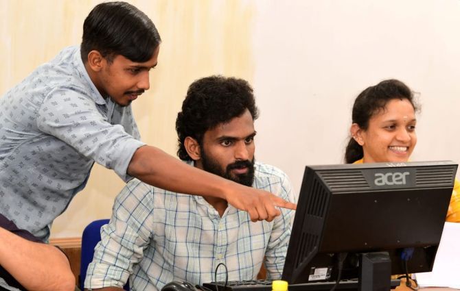 India and Jamshedpur FC footballer CK Vineeth (right) with a co-worker at a government helpline centre