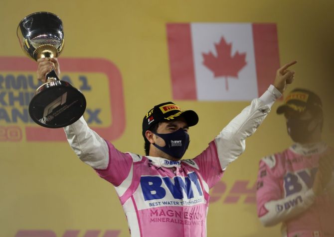 Racing Point's Sergio Perez celebrates on the podium with the trophy after winning the race Sakhir F1 Grand Prix at the Bahrain International Circuit in Sakhir, Bahrain, on Sunday