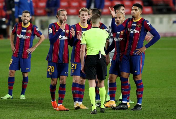 Barcelona players speak to referee Alejandro Hernandez after the match against Valencia