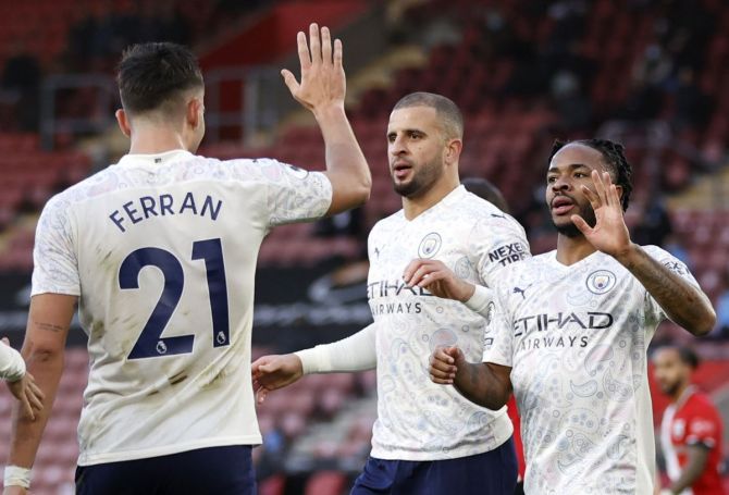 Manchester City's Raheem Sterling celebrates with Kyle Walker and Ferran Torres on scoring their first goal against Southampton at St Mary's Stadium, Southampton