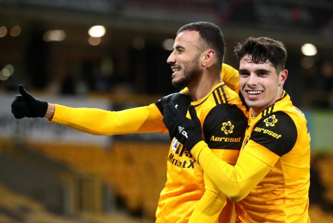 Romain Saiss celebrates with teammate Pedro Neto after scoring for Wolverhampton Wanderers during the Premier League match against Tottenham Hotspur