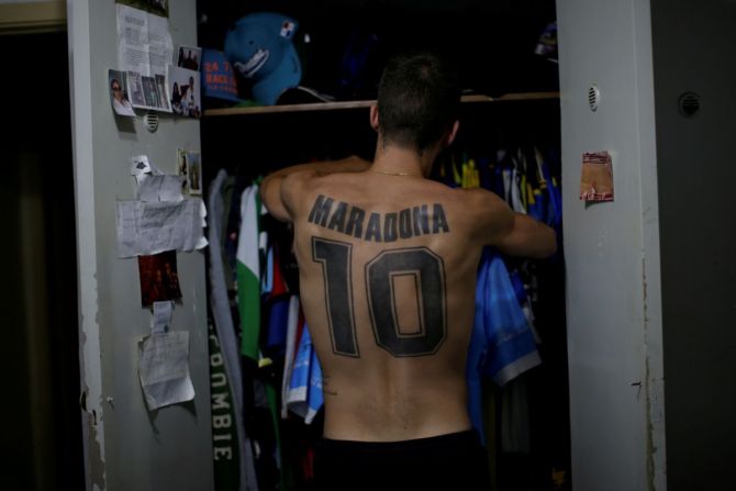 Matias Disciosia who tattooed Maradona's name and former jersey number on his back, looks through his closet at his home in Buenos Aires