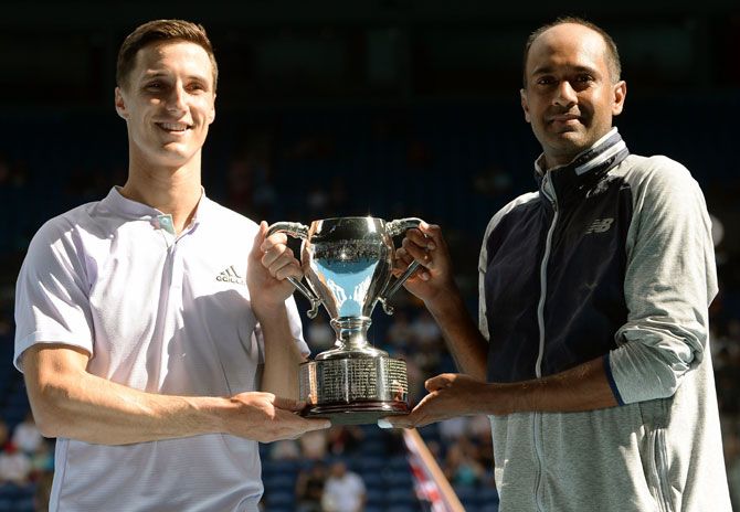 Rajeev Ram of the United States and Joe Salisbury of Great Britain hold aloft the men's doubles trophy at the Australian Open on Sunday.