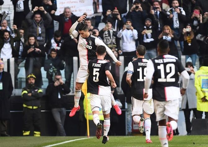 Cristiano Ronaldo celebrates scoring Juventus's first goal with teammates during the Serie A match against Fiorentina