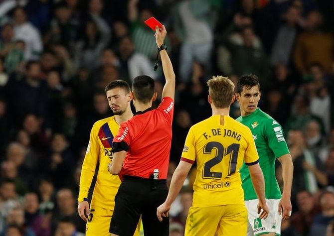 Barcelona's Clement Lenglet is shown a red card by referee Sanchez Martinez during Sunday's La Liga match against  Real Betis. 