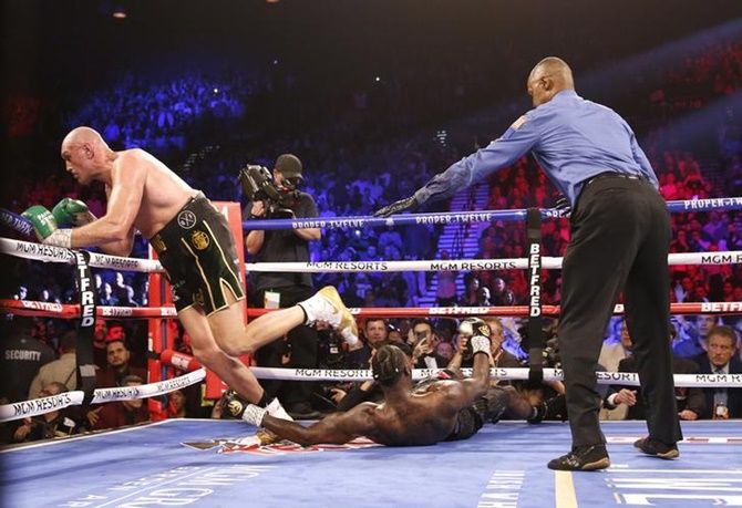 Tyson Fury knocks down Deontay Wilder during the WBC Heavyweight title bout, at the Grand Garden Arena at MGM Grand, Las Vegas, on Saturday.