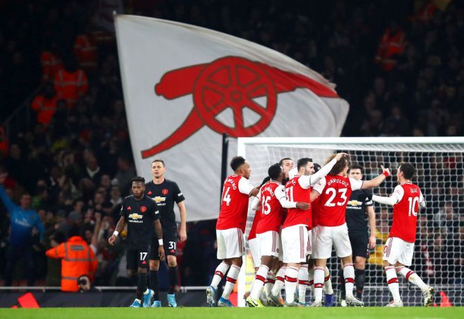 Arsenal's Sokratis Papastathopoulos celebrates with his teammates after scoring his team's second goal against Manchester United at Emirates Stadium in London on Thursday