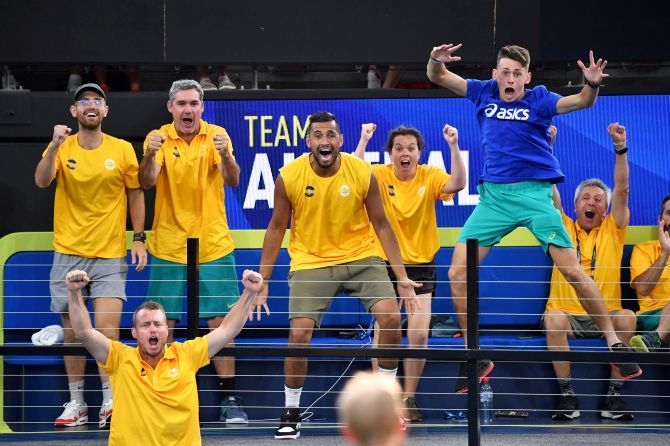 Team Australia players Nick Kyrgios and Alex de Minaur are seen celebrating as their team mates Chris Guccione and John Peers play their doubles match against Felix Auger-Aliassime and Adil Shamasdin of Canada during day 3 of the ATP Cup tennis tournament at Pat Rafter Arena in Brisbane, Australia, on Sunday