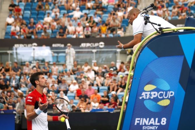 Serbia's Novak Djokovic speaks with the umpire Carlos Bernardes 