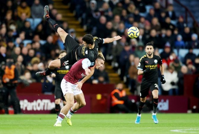 Aston Villa's Jack Grealish and Manchester City's Rodri get tangled as they vie for possession
